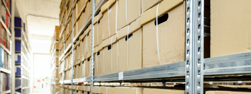 Brown Bankers Boxes Stacked on Metal Shelving Units in A Records Storage Facility